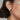A close-up image of a woman wearing a white gold diamond earring with baguettes.