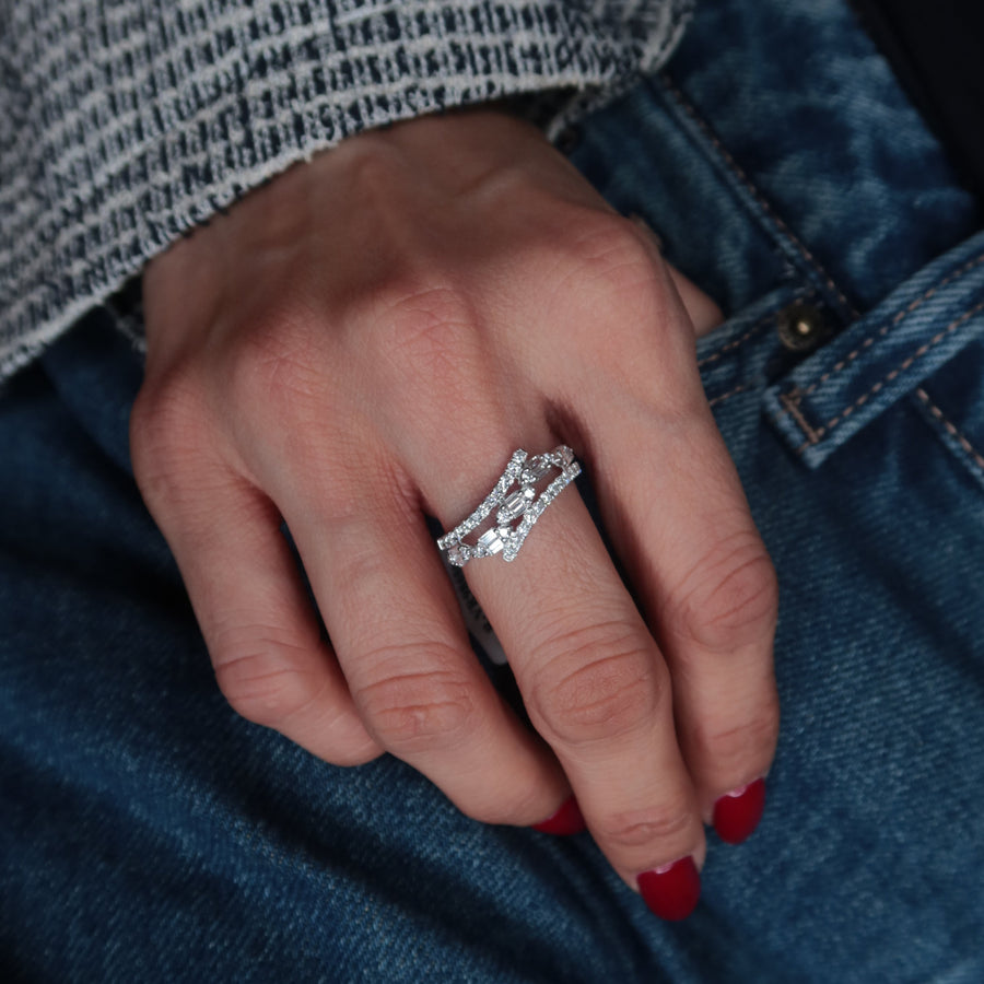 Close-up of a hand wearing a diamond ring with a blue denim background