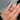 Hand wearing a butterfly diamond ring with a blurred background