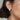 A close-up image of a woman wearing a white gold diamond earring with baguettes.