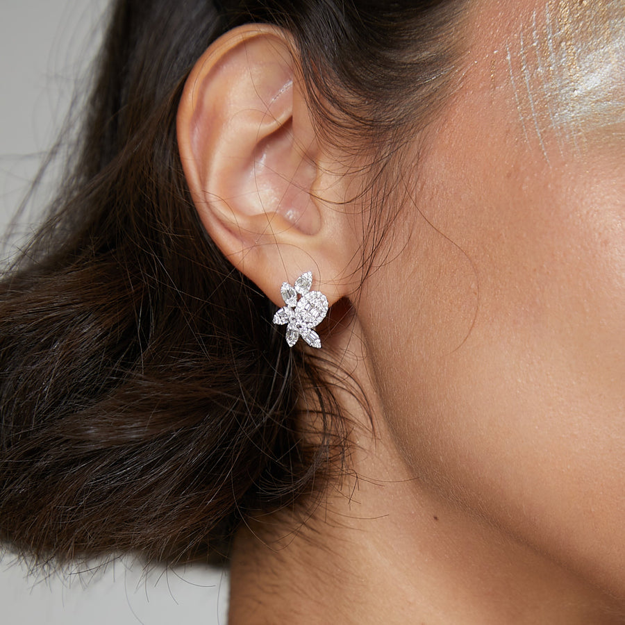 A close-up image of a woman wearing a white gold diamond earring with baguettes.