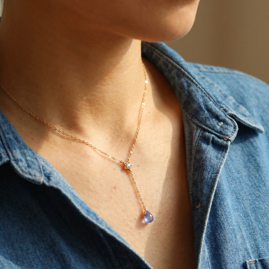 Model wearing a delicate Alula necklace with a blue denim shirt