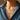 Close-up of a model wearing Alula delicate necklace with a blue pendant, set against a neutral background.