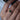 Close-up of a hand wearing a diamond ring with a zambian pear shaped emerald gemstone.