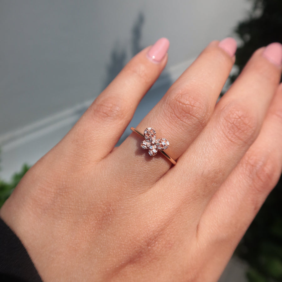 Hand wearing a butterfly diamond ring with a blurred background