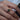 Close-up of a hand wearing a diamond ring with a zambian pear shaped emerald gemstone.