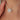 Close-up of a silver necklace with a diamond pendant on a person's skin.