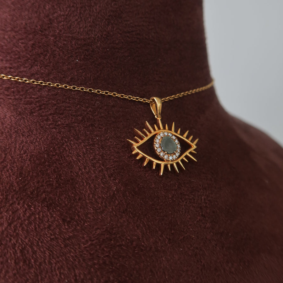 Gold necklace with a pendant on a brown velvet surface